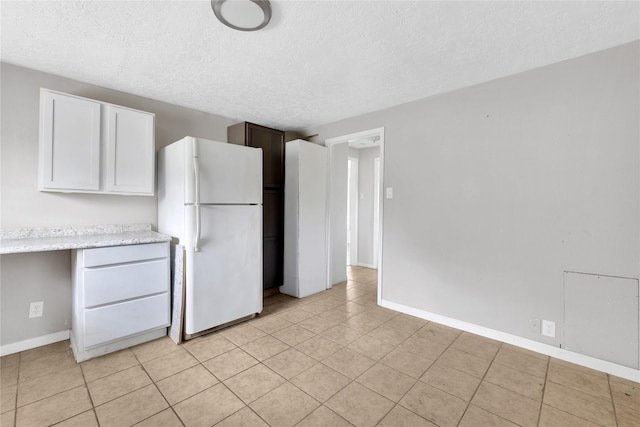 kitchen featuring built in desk, a textured ceiling, and white refrigerator