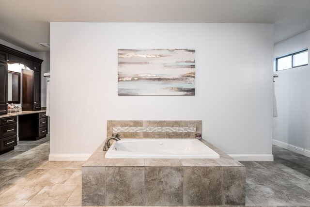 bathroom featuring vanity and a relaxing tiled tub