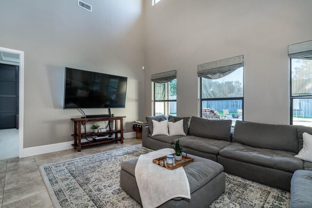 living room with light tile patterned floors and a towering ceiling