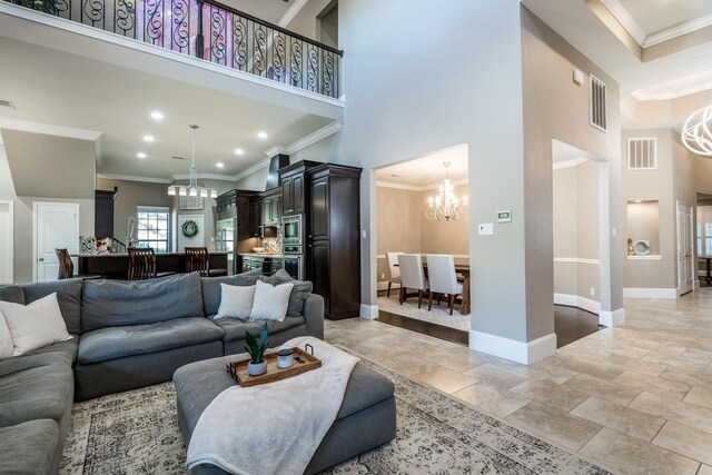 living room with a high ceiling, ornamental molding, and an inviting chandelier