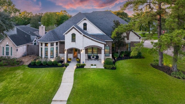 french country inspired facade with a yard