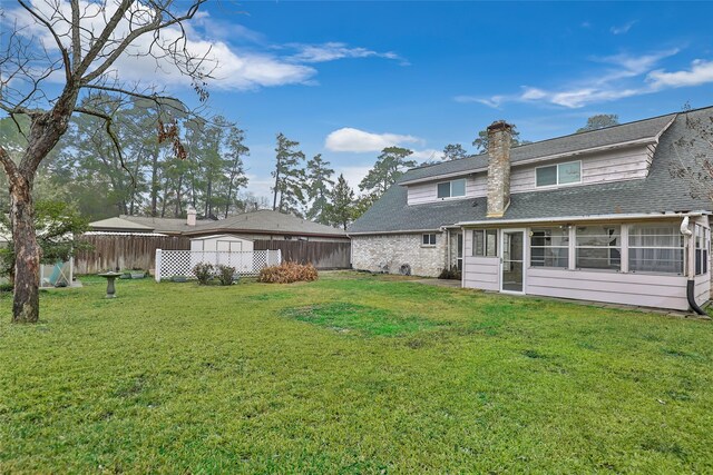 back of property with a sunroom and a lawn