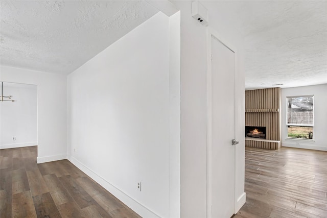 hallway with dark wood-type flooring and a textured ceiling