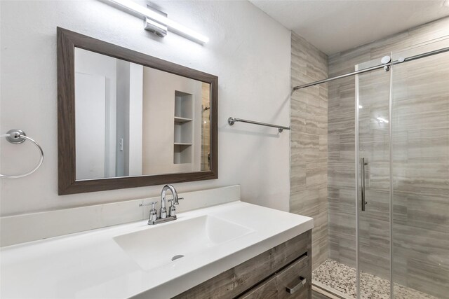 bathroom with vanity and a shower with shower door