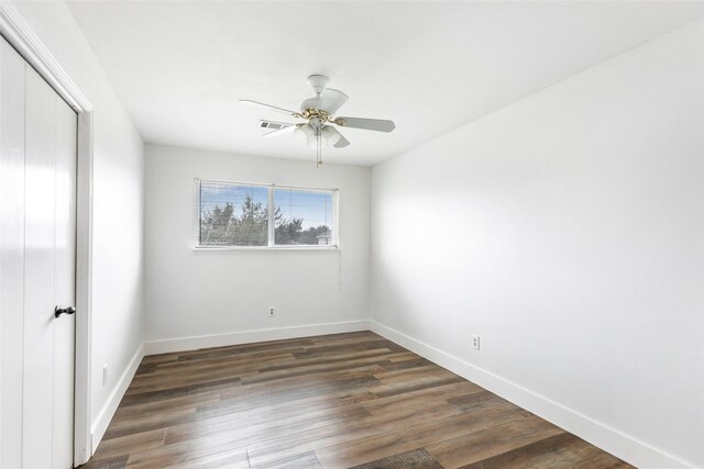 empty room with dark wood-type flooring and ceiling fan