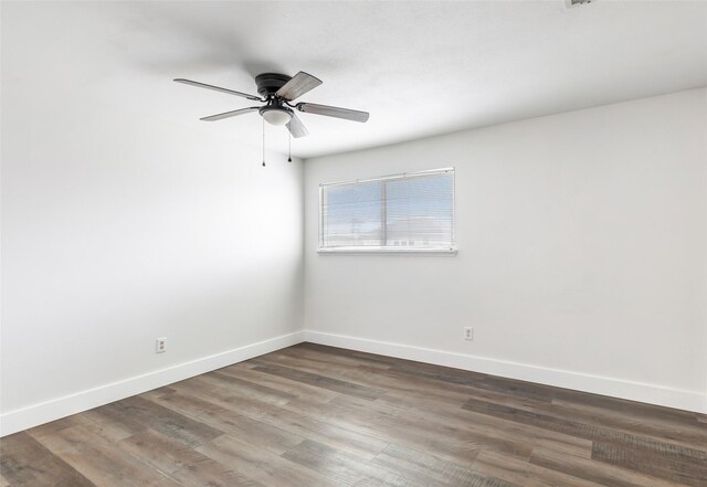 spare room with dark wood-type flooring and ceiling fan