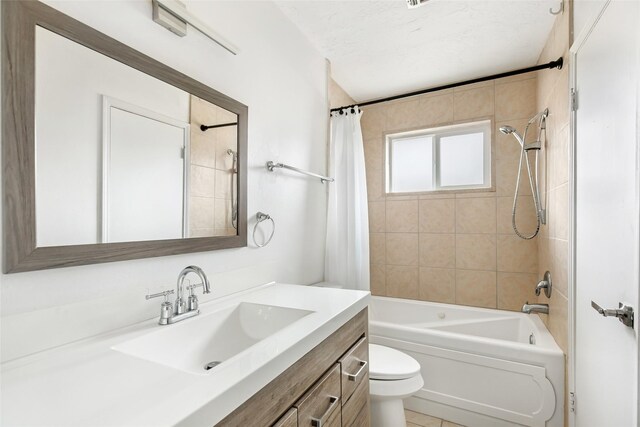 full bathroom featuring vanity, toilet, a textured ceiling, and shower / bath combo with shower curtain