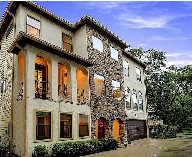 1826 Portsmouth St Unit A, Houston, TX 77098 - view of front facade with a garage, stucco siding, concrete driveway, and stone siding