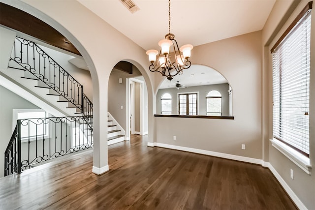 foyer with dark hardwood / wood-style floors and ceiling fan with notable chandelier