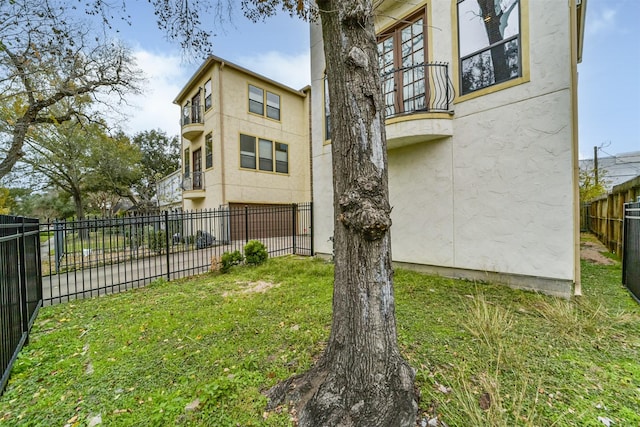 1826 Portsmouth St Unit A, Houston, TX 77098 - view of home's exterior with a balcony, a lawn, stucco siding, and fence