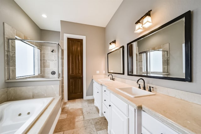 bathroom featuring vanity and independent shower and bath