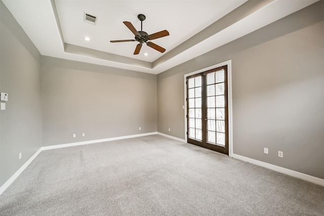 empty room featuring french doors, ceiling fan, a raised ceiling, and carpet floors