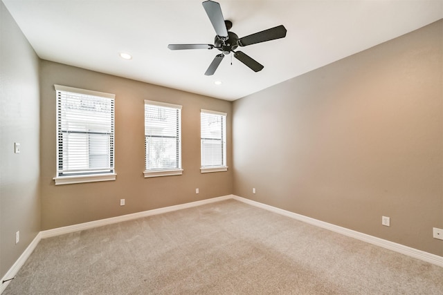 spare room featuring light colored carpet and ceiling fan