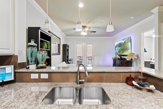 kitchen featuring ornamental molding, sink, ceiling fan, and light stone counters