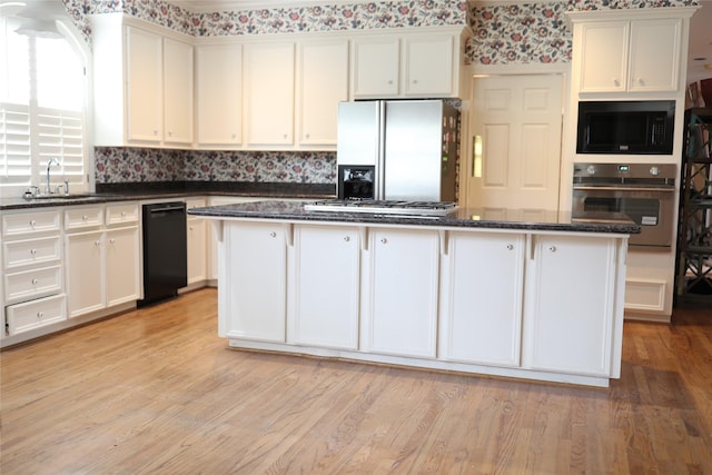 kitchen featuring white cabinetry, a center island, sink, and black appliances