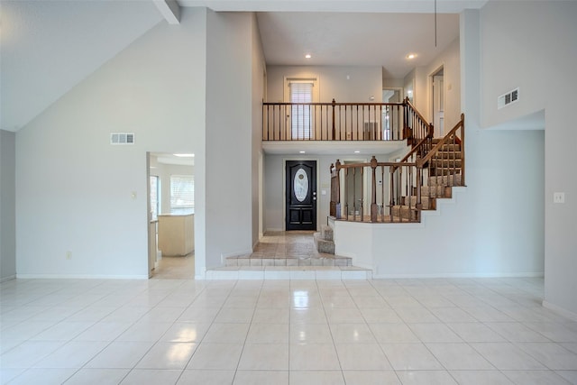 tiled entryway featuring beam ceiling and high vaulted ceiling