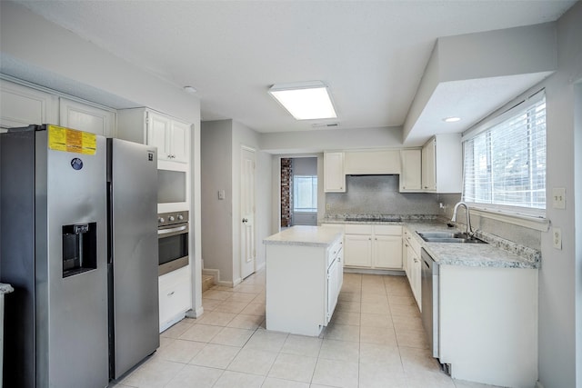 kitchen with sink, white cabinetry, tasteful backsplash, a kitchen island, and stainless steel appliances