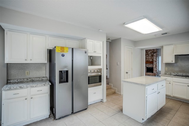 kitchen with white cabinetry, tasteful backsplash, appliances with stainless steel finishes, and a kitchen island