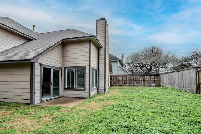 rear view of property with a yard and a patio area