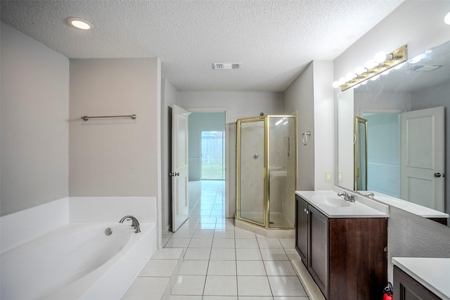 bathroom with independent shower and bath, vanity, tile patterned floors, and a textured ceiling