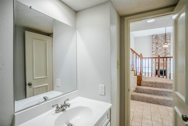 bathroom with vanity, radiator, tile patterned floors, and a textured ceiling