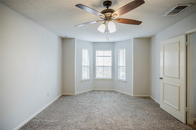 unfurnished room with ceiling fan, light colored carpet, and a textured ceiling