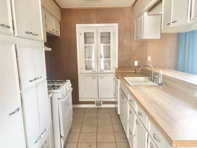 kitchen with sink, gas range gas stove, and white cabinets