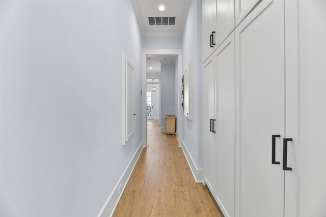 hall with crown molding and light hardwood / wood-style floors