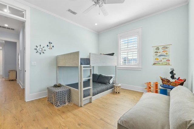 bedroom with crown molding, light hardwood / wood-style floors, and ceiling fan