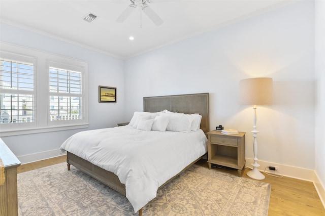 bedroom with hardwood / wood-style flooring, crown molding, and ceiling fan