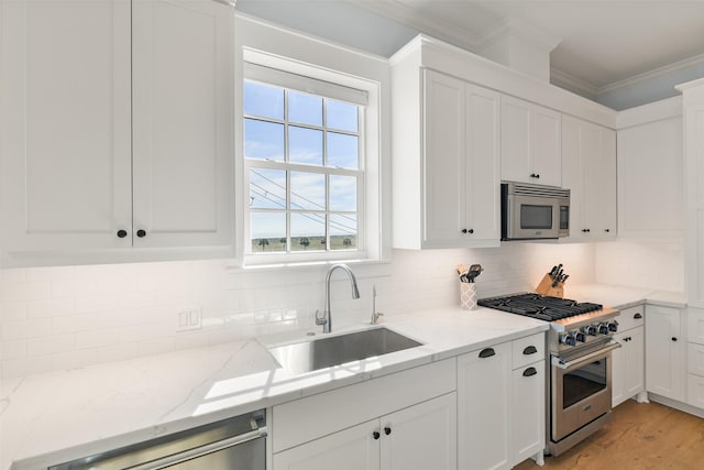 kitchen featuring appliances with stainless steel finishes, light stone countertops, sink, and white cabinets