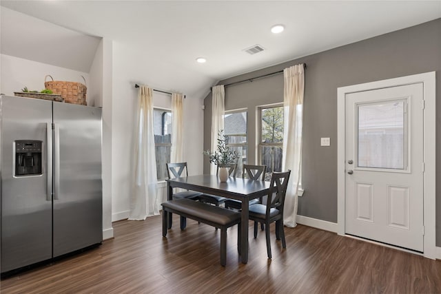 dining space with vaulted ceiling and dark wood-type flooring