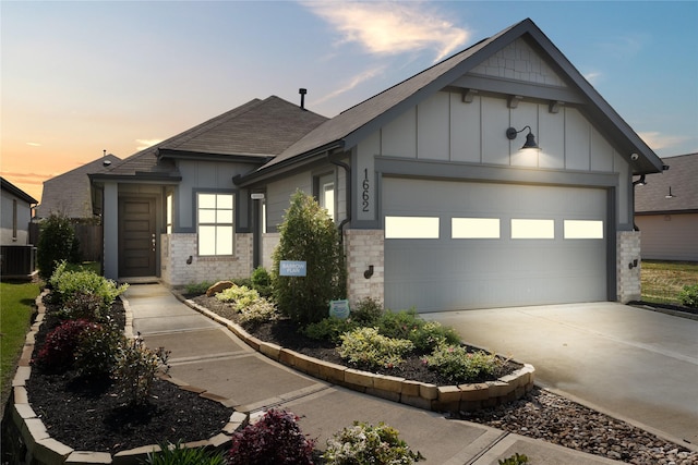 view of front of house featuring a garage and central AC