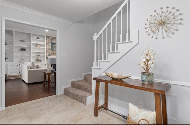 staircase with crown molding, built in features, and a textured ceiling