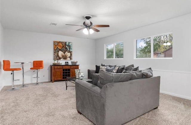 carpeted living room with ceiling fan