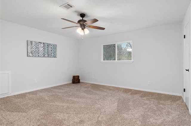 empty room with ceiling fan, carpet flooring, and a textured ceiling