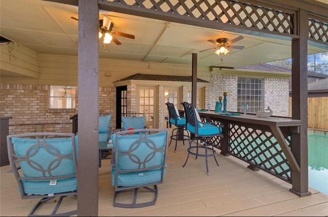 deck featuring ceiling fan and exterior bar