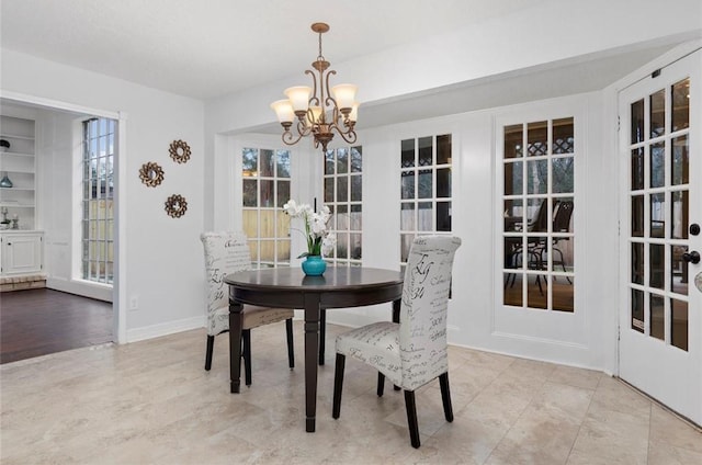 dining area with built in features and an inviting chandelier