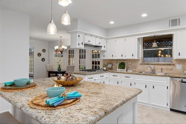 kitchen featuring sink, white cabinetry, stainless steel appliances, light stone counters, and tasteful backsplash