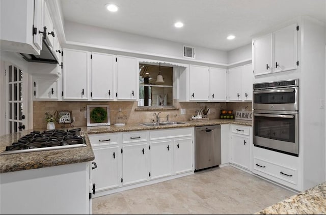 kitchen featuring sink, white cabinetry, stone countertops, appliances with stainless steel finishes, and backsplash