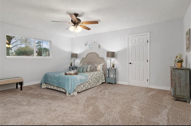 bedroom with ceiling fan, carpet floors, and a textured ceiling