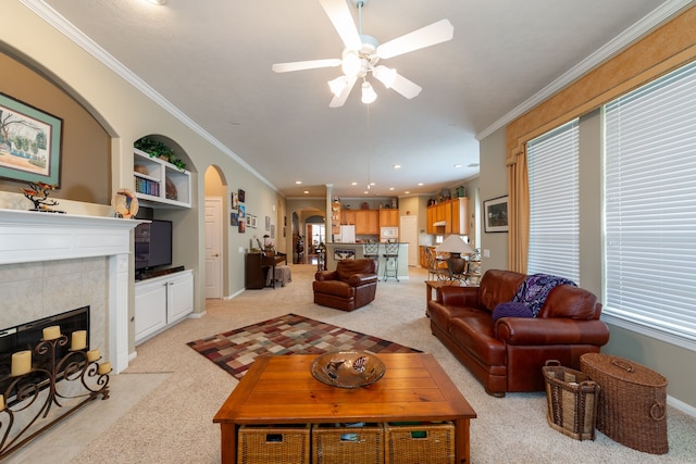 living room featuring light carpet, crown molding, and a tile fireplace