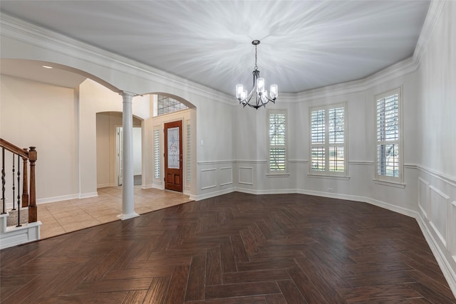 unfurnished dining area with ornamental molding, decorative columns, and light parquet floors