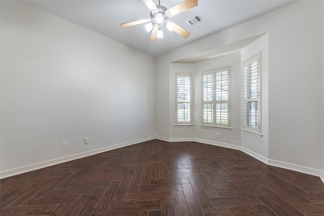 spare room featuring dark parquet floors and ceiling fan