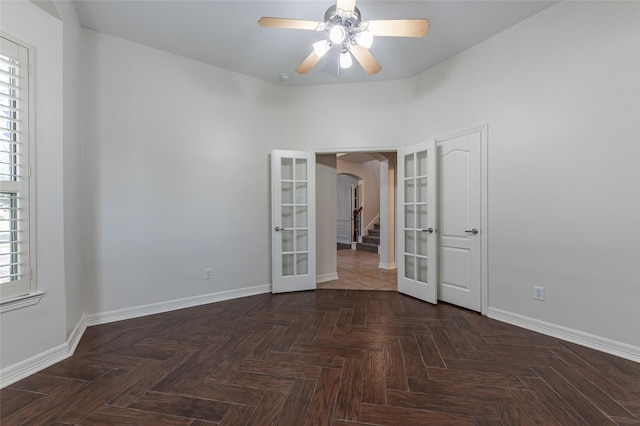 unfurnished room with french doors, ceiling fan, and dark parquet floors