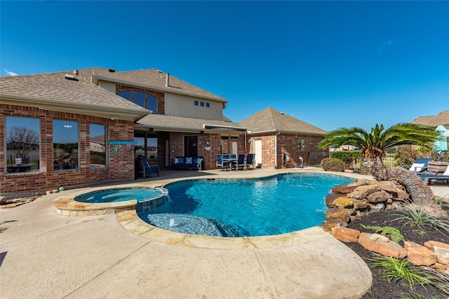 view of swimming pool with an in ground hot tub and a patio area