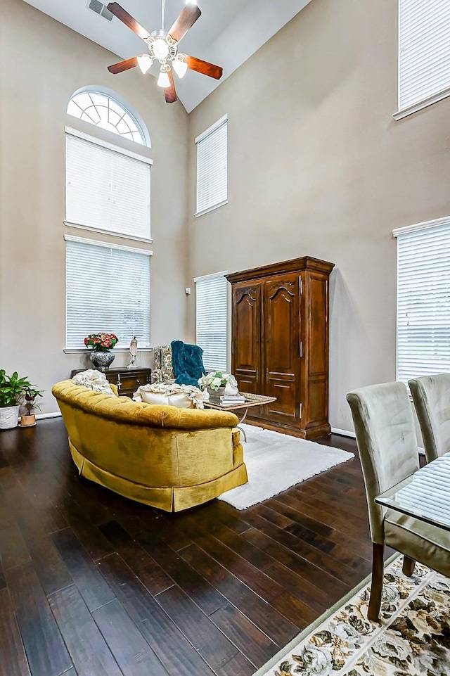 sitting room featuring a high ceiling, hardwood / wood-style floors, and ceiling fan