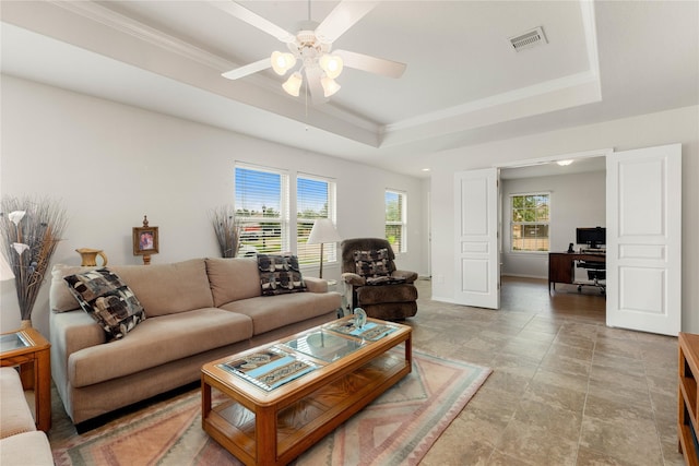 living room featuring ornamental molding, a raised ceiling, and ceiling fan