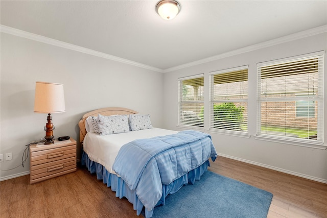 bedroom with ornamental molding and hardwood / wood-style floors