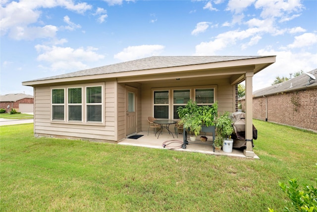 back of property featuring a yard and a patio